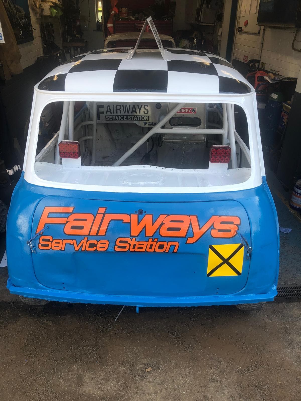Rear view of a stock car with chequered flag paint